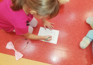 dziewczynka zapisuje ile cm mierzy jej miś